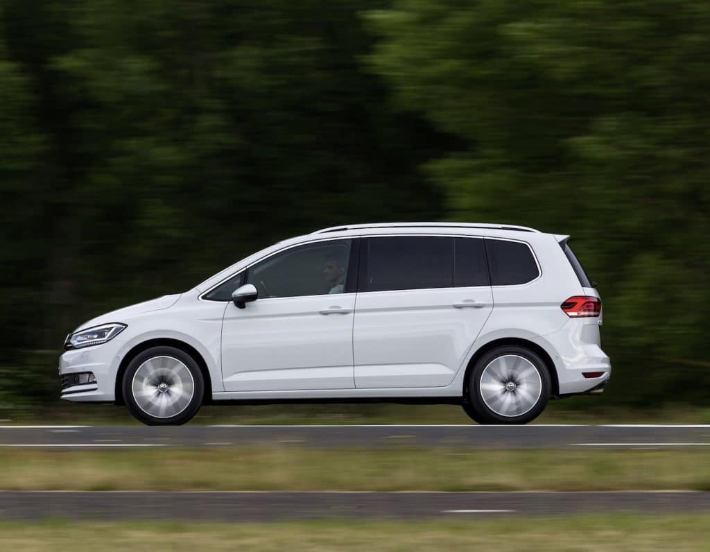 volkswagen touran driving in singapore in front of a forest