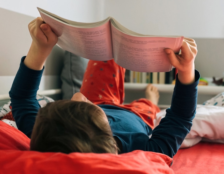 Boy reading on his bed