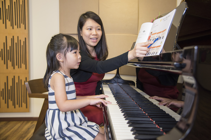 child learning to play the piano at aureus academy music camp
