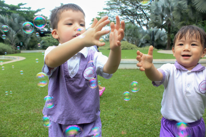 child plays with bubbles at mulberry learning centre preschool in singapore