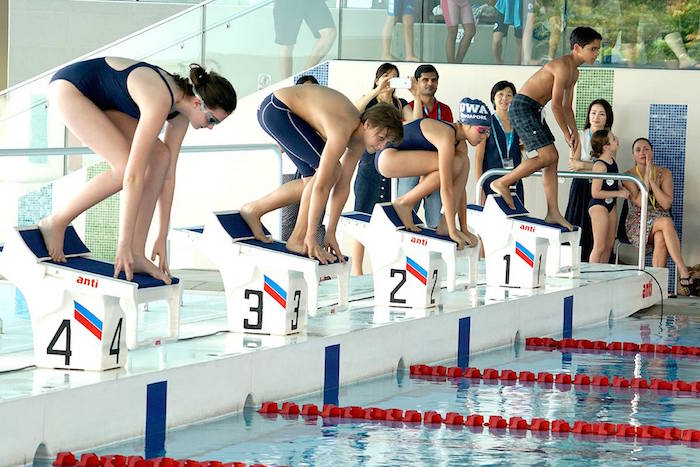 children on the starting blocks at a swim meet at GEMS World Academy Singapore