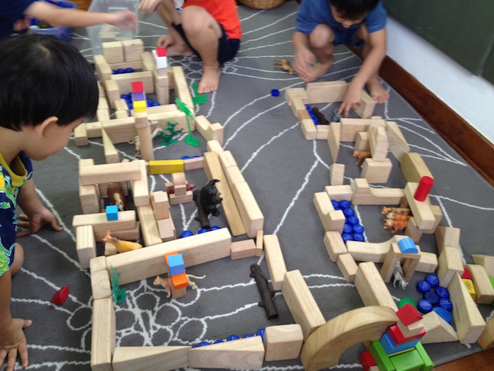 playing with blocks at between two trees early learning school
