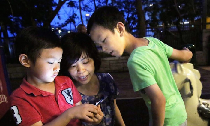 parents playing pokemon go with kids