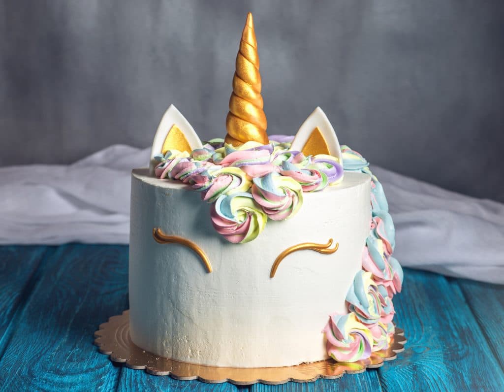 Beautiful bright cake decorated in the form of fantasy unicorn. Concept of a festive dessert for kids birthday