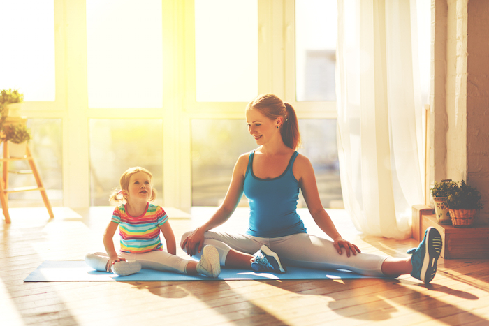 a mother and child doing yoga together