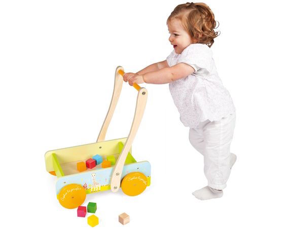 a baby plays with a walker wagon to hit toddler milestones