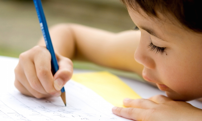 Little boy writing a letter