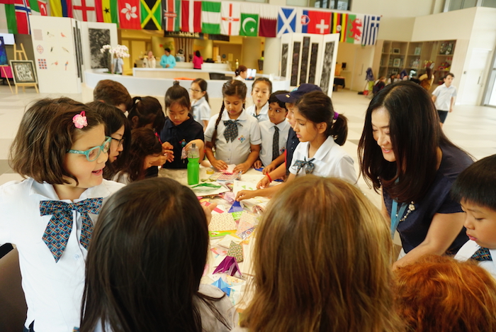 Kids folding origami during arts week at GEMS World Academy Singapore