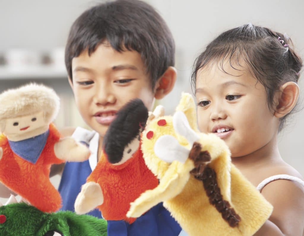 Sibling playing hand puppet