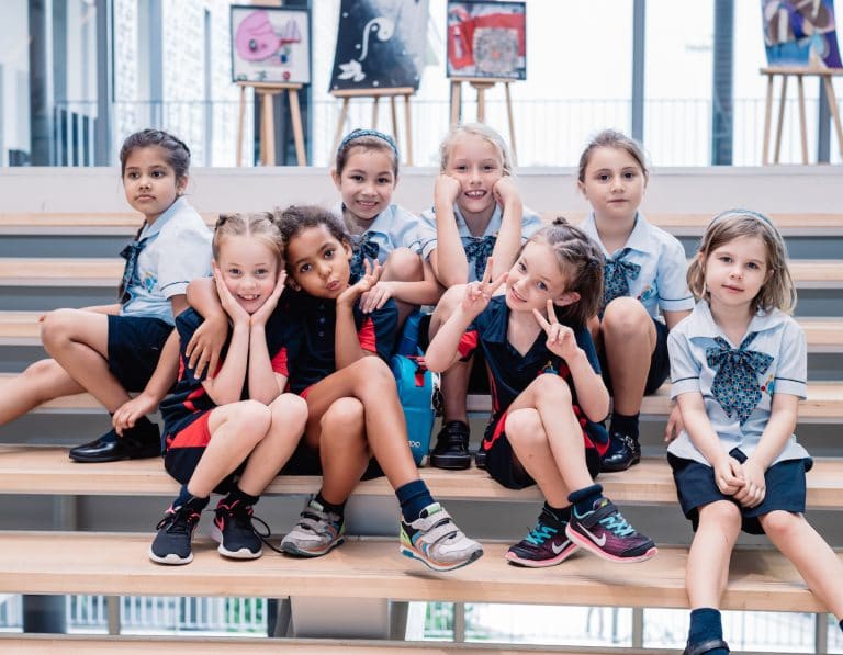 early years learning at GEMS World Academy Singapore girls on staircase friends fun