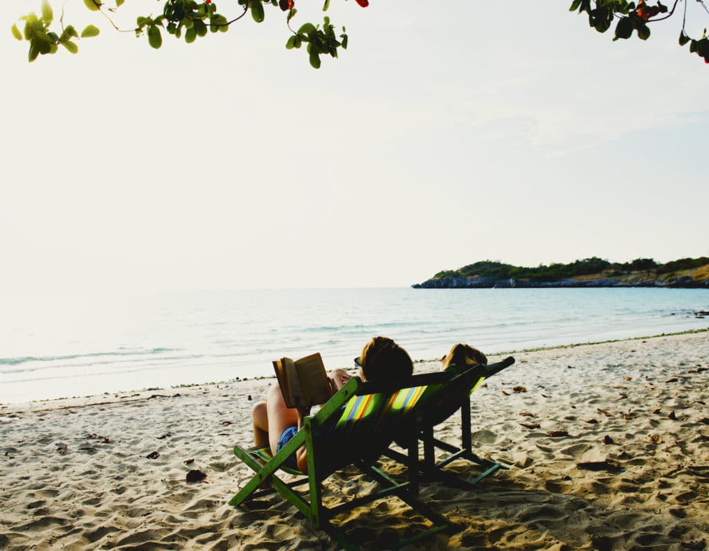 Girlfriends relax and reading on the beach