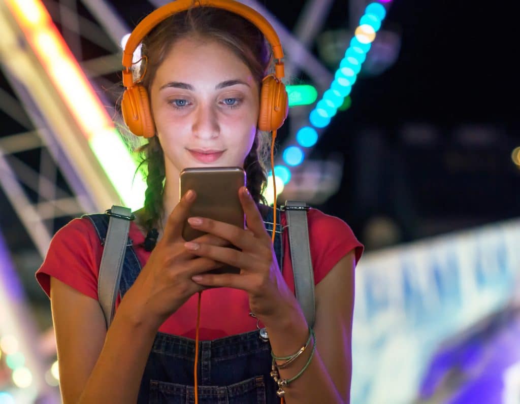 Young girl in amusement park using her smartphone