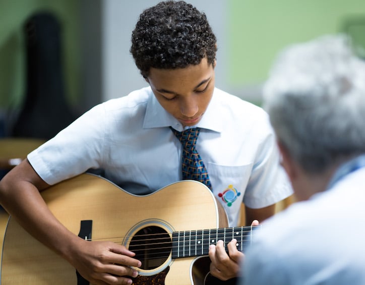 global education boy learns guitar at gems world academy singapore