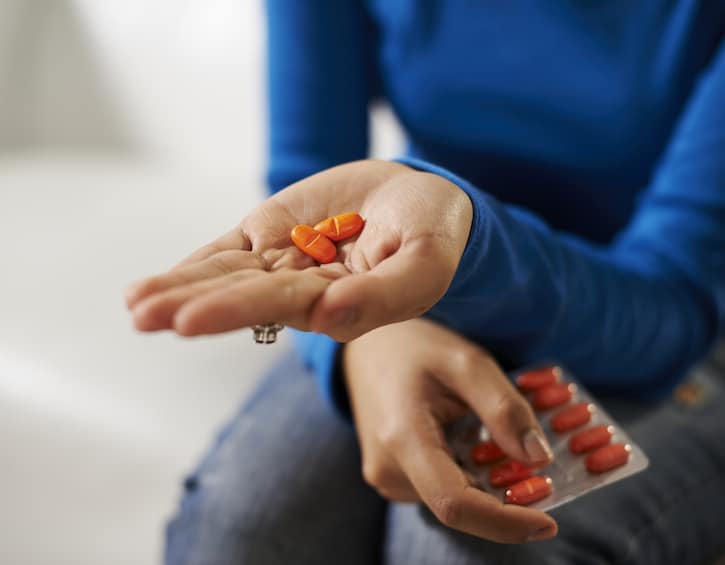 asian woman holding pills and medicine in hand