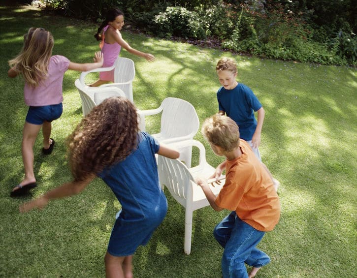 Children playing ‘musical chairs’ in back yard