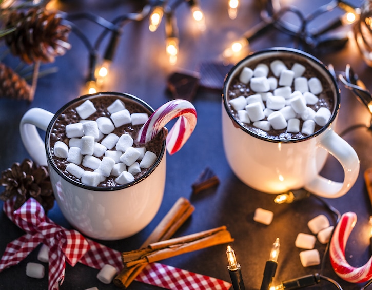 Two homemade hot chocolate mugs with marshmallows on Christmas table