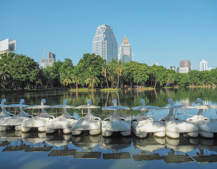 Bangkok cityscape lumpini park lake view with a row of Swan Pedal Boats