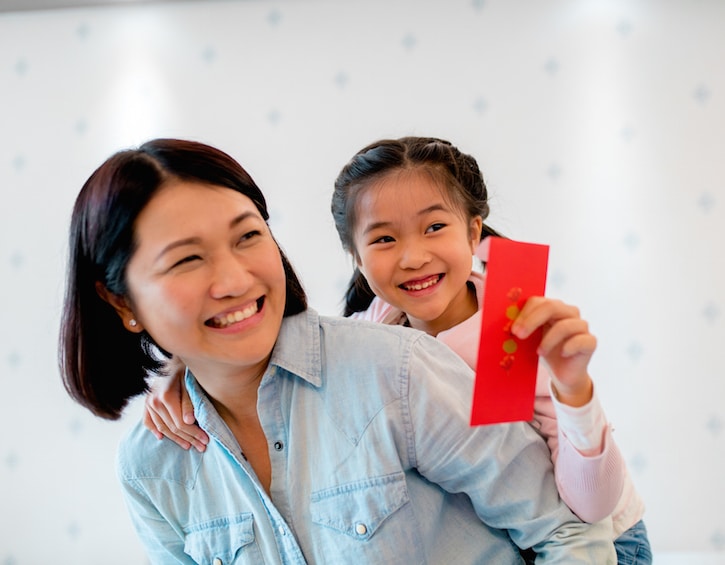 Young holding a red envelope for Chinese new year