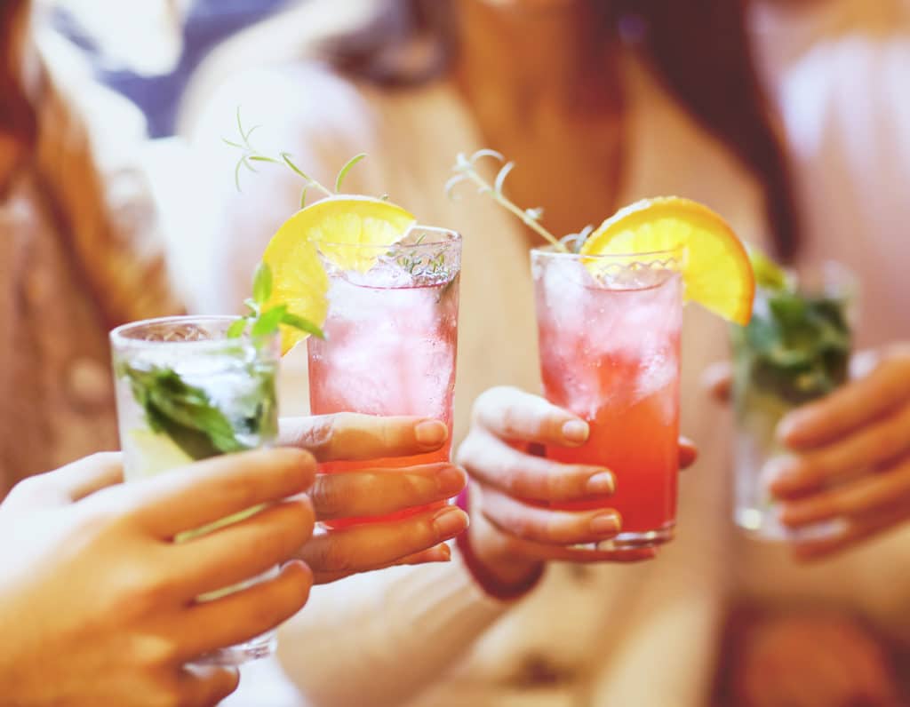 Young men and women drinking cocktail at party