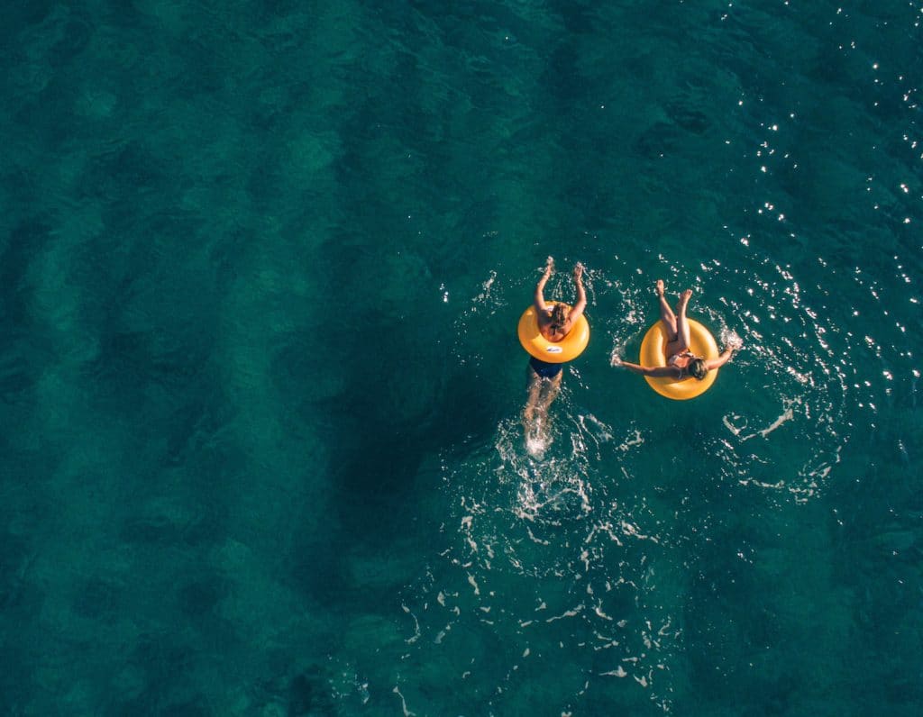 two women floating in the ocean on a girls trip retreat