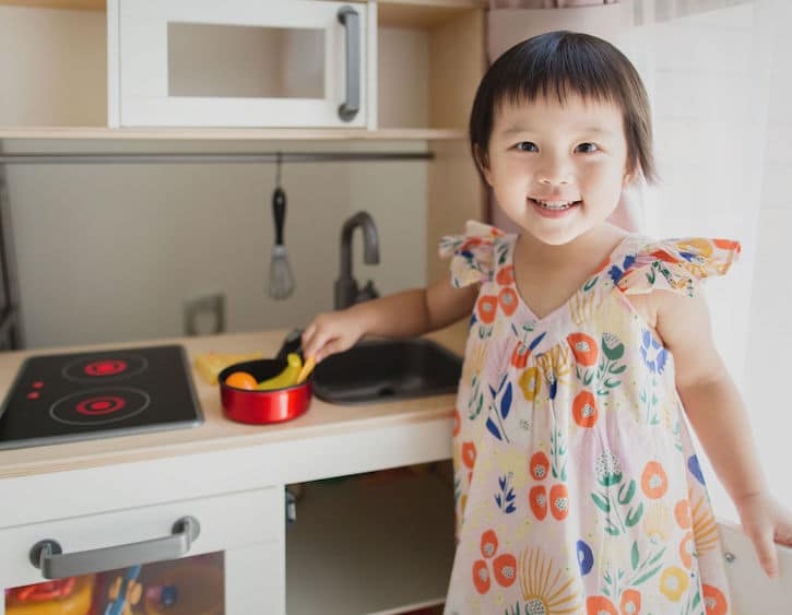 a child plays with a toy kitchen
