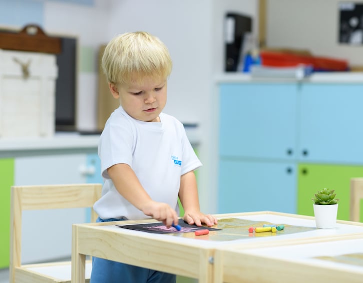 a Little Gems Nursery student making art to hone fine motor skills 