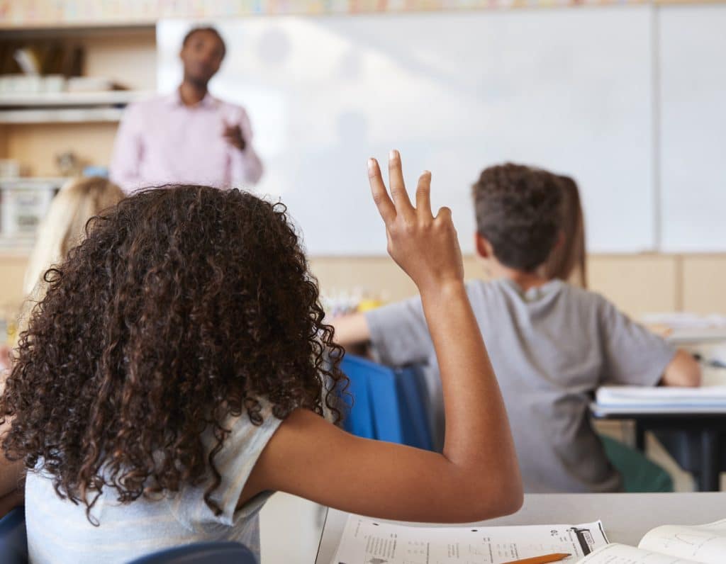 middle school student raising hand in class