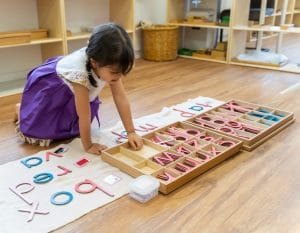 a child learns her letters at house on the hill montessori
