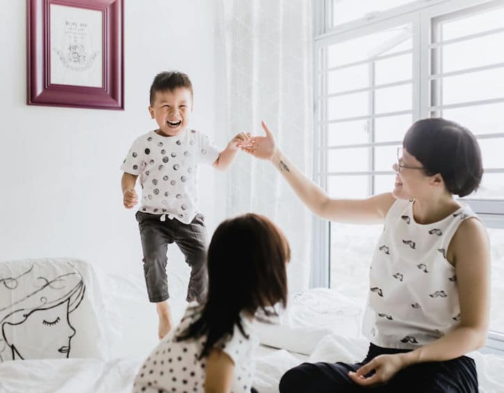 that mama artist illustrator gracie chai with her son jumping on the bed