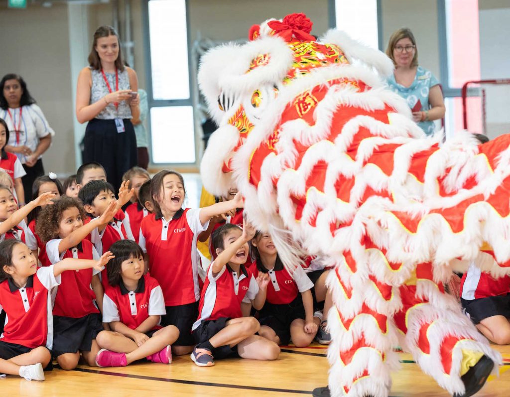 students in the cis chinese-english bilingual programme cheer for a lion dance