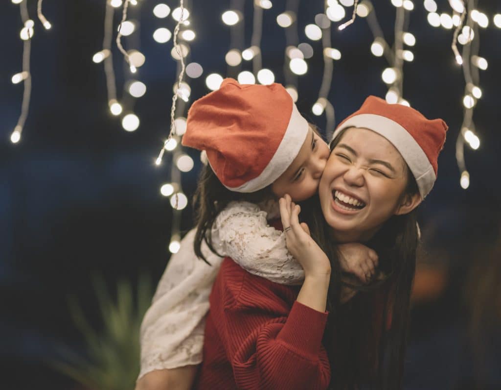 an asian chinese female carrying her sister from the back during christmas eve dinner celebration
