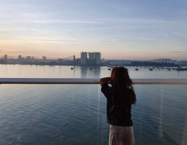 child watches sunrise over port klang from balcony stateroom on board royal caribbean cruise ship quantum of the seas