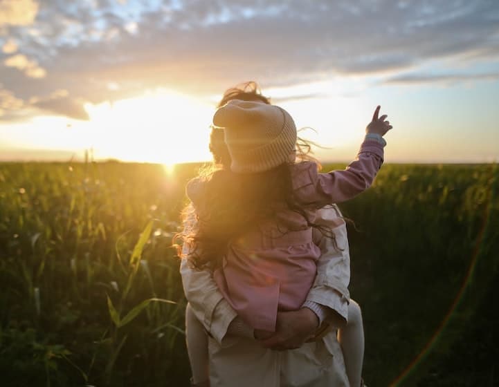 tween parenting holding daughter sunrise