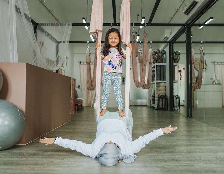 that-mama-nura-ahmad-her-tribe-yoga-studio-daughter-playing-swings-min