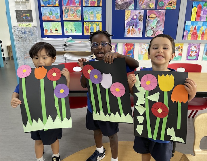 OWIS Open House Students with Artwork of Flowers